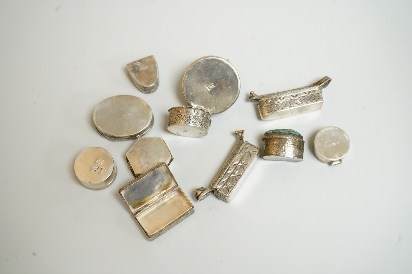 A collection of assorted pill boxes including one modern circular silver, a Mexican 925, six continental white metal, one inset with chalcedony and two with niello decoration and three other unmarked white metal pill box